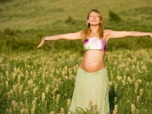 Attractive_pregnant_woman_in_the_meadow_enjoying_sun_and_nature